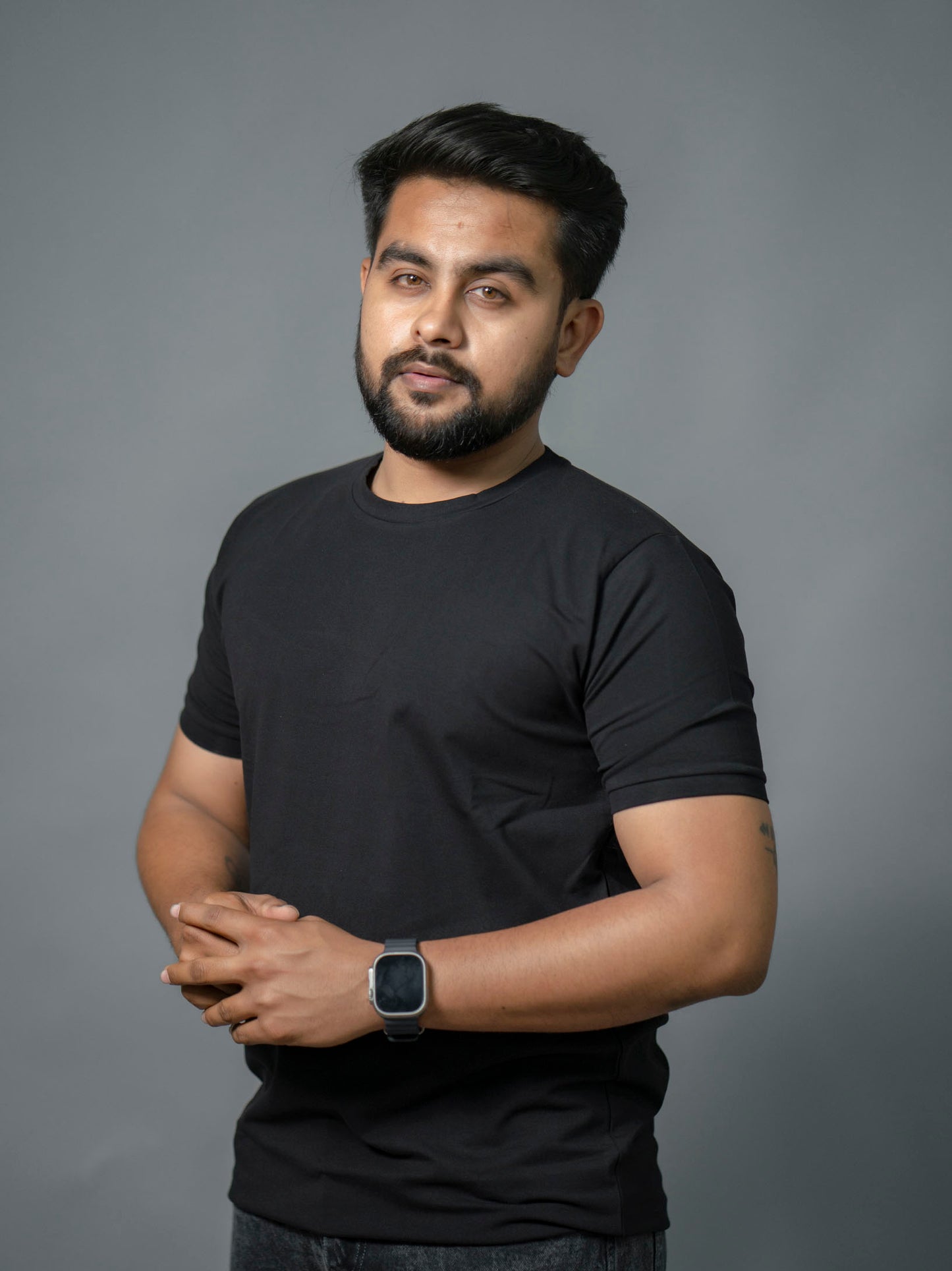 Man wearing a black t-shirt against a gray background