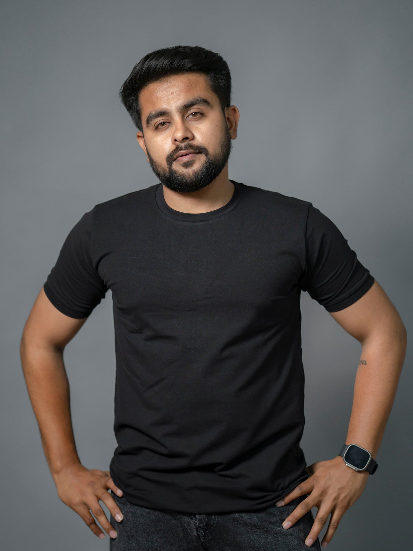Man wearing a black t-shirt against a gray background